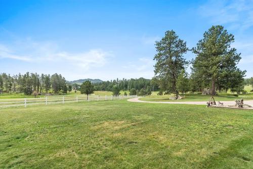 a grassy field with a fence and a road at Papa’s Place on Willow Creek in Custer
