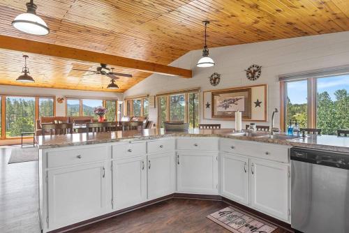 a kitchen with white cabinets and a wooden ceiling at Papa’s Place on Willow Creek in Custer