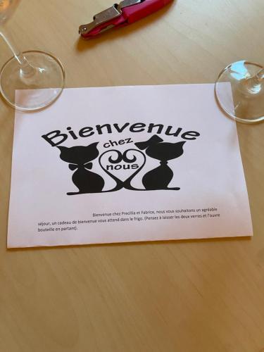 um sinal sentado em cima de uma mesa com óculos em Chez Precillia et Fabrice em Montlaur