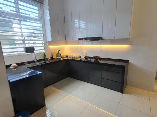 eine Küche mit schwarzen Schränken und einem großen Fenster in der Unterkunft JOVIAL SingleStorey Bungalow 4Room10Pax `Alma in Bukit Mertajam