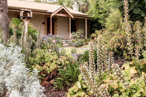 a garden with flowers in front of a house at Cole-Brook Cottage Historic House in McLaren Vale