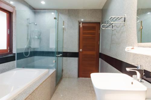 a bathroom with a tub and a shower and a sink at Ruen Thai Siray Green in Phuket