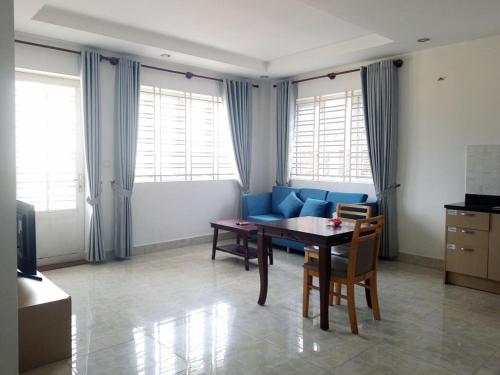een woonkamer met een tafel en een blauwe bank bij Murrayrata in Phnom Penh