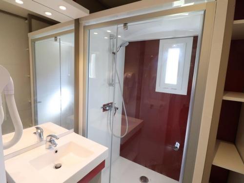 uma casa de banho com um chuveiro e um lavatório. em Gîte Le Rouget-Pers, 3 pièces, 4 personnes - FR-1-742-362 em Le Rouget