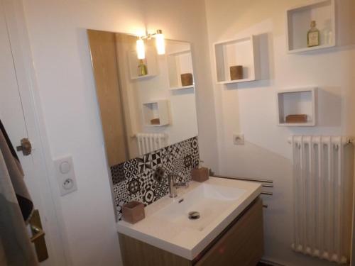 La salle de bains est pourvue d'un lavabo et d'un miroir. dans l'établissement Appartement Aurillac, 2 pièces, 2 personnes - FR-1-742-389, à Aurillac