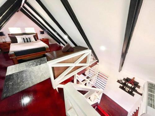a loft bedroom with a bed and a staircase at Cozy Bure in Pacific Harbour