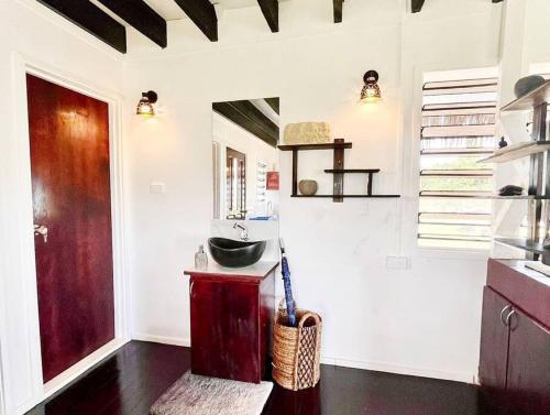 a kitchen with a sink and a door in a room at Cozy Bure in Pacific Harbour