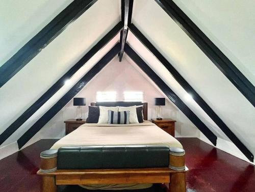 a bedroom with a bed in a attic at Cozy Bure in Pacific Harbour