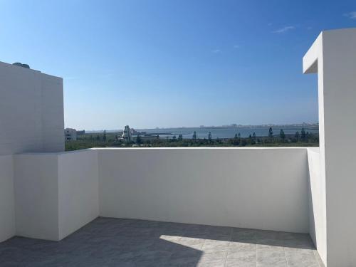 a white wall with a view of the ocean at Mian Bao Homestay in Magong