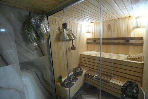 a sauna with a shower and a tub in a room at Guest House in Gyumri