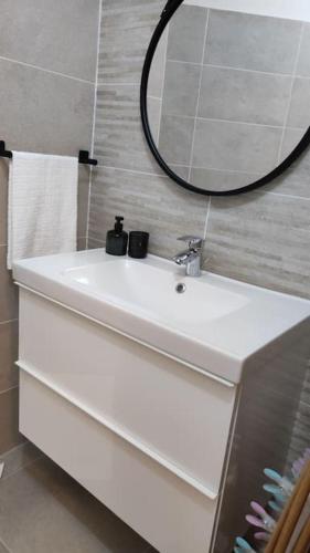 une salle de bain avec un lavabo blanc et un miroir dans l'établissement appartement perpignan, à Perpignan