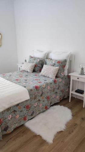 a bedroom with a bed with a blanket and a table at Appartement Perpignan in Perpignan