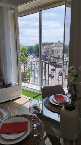 une table de salle à manger avec vue sur un balcon dans l'établissement appartement perpignan, à Perpignan
