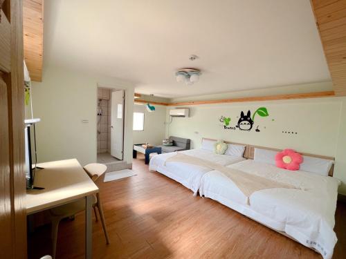 1 dormitorio con 1 cama blanca grande con flores en la pared en Dan Bao Homestay, en Jincheng