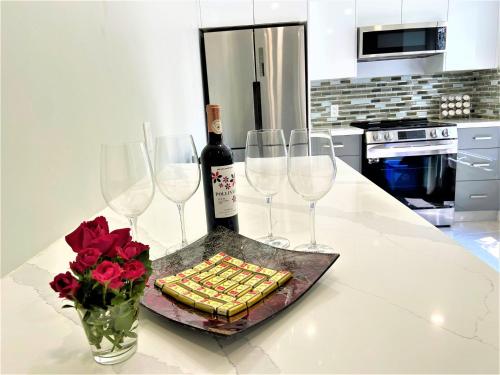 iResidence in Toronto - Fantastic Vacation Home في تورونتو: طاولة مع ثلاثة كؤوس من النبيذ وزجاجة من النبيذ