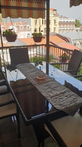 una mesa y sillas en un balcón con sombrilla en Roman Stadium Apartments, en Plovdiv