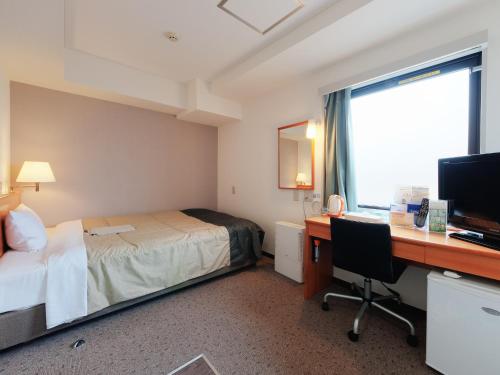 Habitación de hotel con cama y escritorio con ordenador en Super Hotel Tokyo Akabane, en Tokio