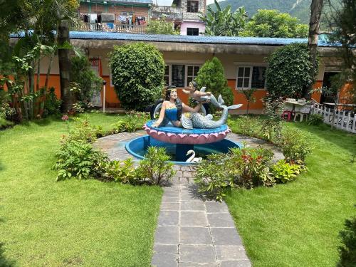 a garden with a statue of two women sitting on a ride at Hotel Benju in Kusma