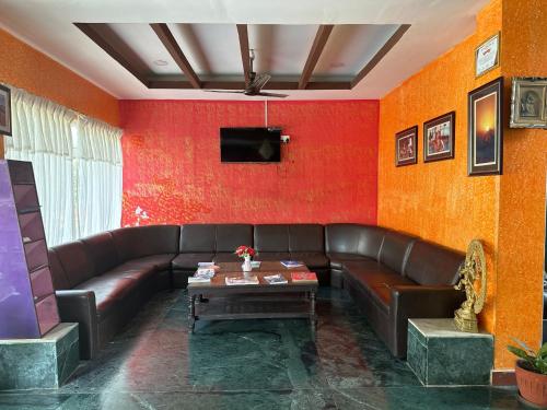a living room with a leather couch and a table at Hotel Benju in Kusma