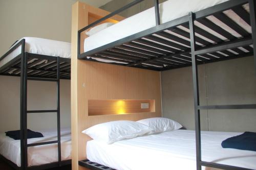 a bedroom with two bunk beds with white sheets at The 80's Guesthouse in George Town