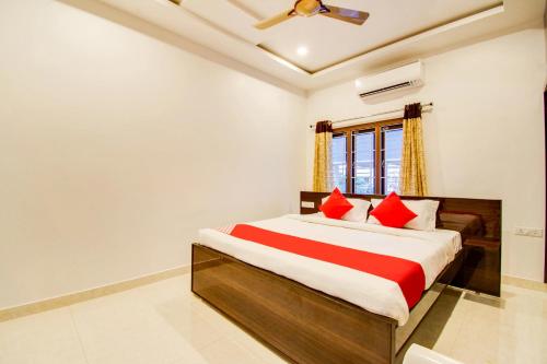 1 dormitorio con 1 cama grande con almohadas rojas en Hotel RVN, en Nellore