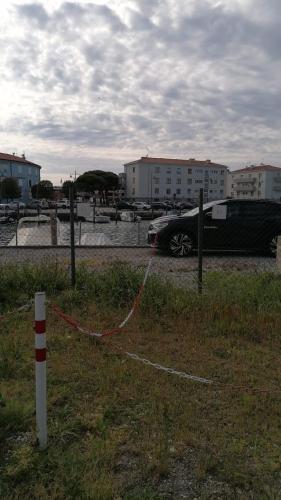 a car parked in a parking lot with a red and white pole at Residence Aprilia in Grado