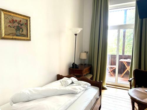a bedroom with a bed and a window and a table at Jahrhunderthotel Leipzig in Leipzig