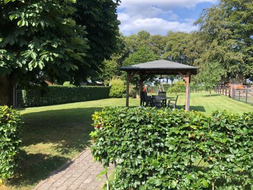 einen Pavillon mit einem Tisch und Stühlen in einem Park in der Unterkunft Ferienhaus Janne in Monschau