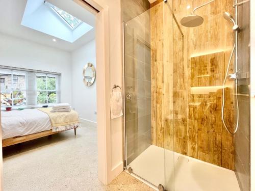 a bathroom with a shower and a bedroom with a bed at Tropical Gardens 1 bed cottage Central Newlyn in Newlyn