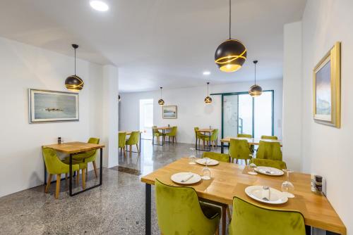 une salle à manger avec une table et des chaises vertes dans l'établissement Boutique rooms Kican, à Metković