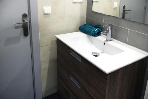bagno con lavandino bianco e specchio di ACOGEDOR APARTAMENTO CERCA DE BARCELONA a Mollet del Vallès