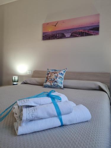 una pila de toallas sentadas encima de una cama en Realmonte Casa vacanze Realbeach en Realmonte