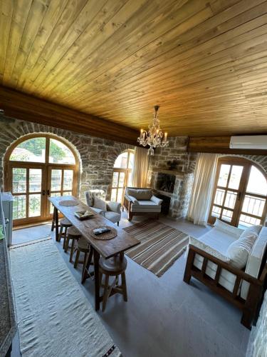 a living room with a wooden ceiling and a table at KİNZİ İMROZ in Gokceada Town