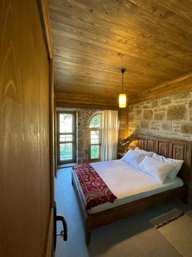 een slaapkamer met een bed en een houten plafond bij KİNZİ İMROZ in Gokceada Town