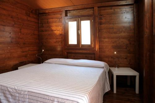 a bedroom with a white bed and a window at Villaggio Camping Calapineta in Siniscola