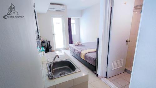 baño con lavabo y 1 cama en una habitación en Springlake Summarecon Bekasi Apartement by RNA, en Rawabugel