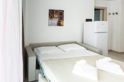 a bedroom with a bed and a white refrigerator at Residence Aprilia in Grado