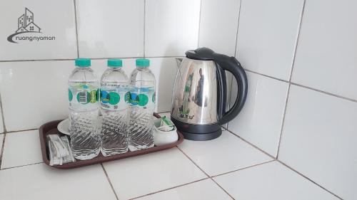 a bottle of water and a kettle on a kitchen counter at Springlake Summarecon Bekasi Apartement by RNA in Rawabugel