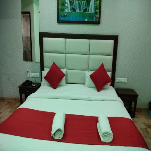 a bedroom with a large bed with red and white pillows at Sea Shell Beach Cottages & Suites in Arambol