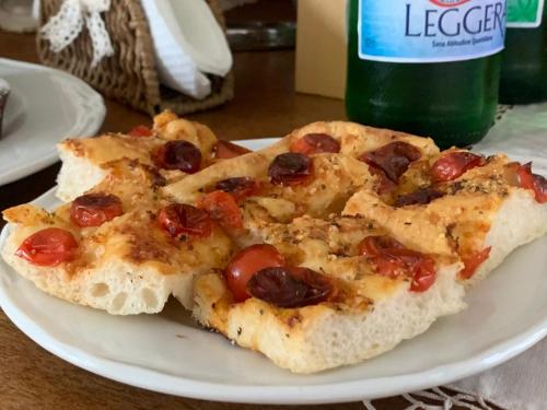 two slices of pizza on a plate next to a bottle at Agriturismo Masseria Cannella in Lesina