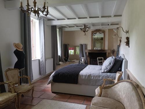 1 dormitorio con cama, silla y espejo en La Maison De Marthe, en Malleval
