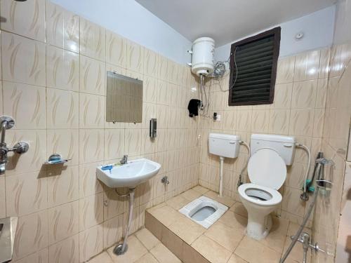 a bathroom with a toilet and a sink at Surya Niwesh 103 in Varanasi