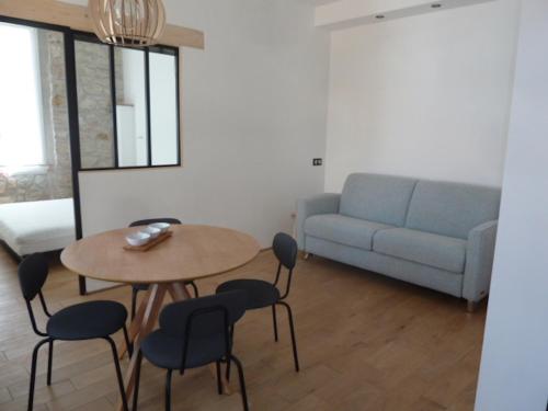a living room with a table and chairs and a couch at Charmant appartement cosy in Saint-Raphaël