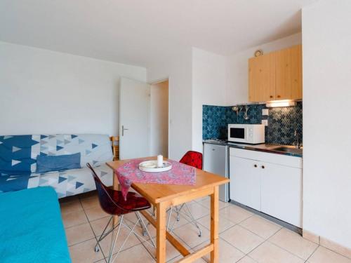 une petite cuisine avec une table et des chaises dans une pièce dans l'établissement Appartement T2 à Narbonne-Plage - 30m de la plage, balcon, 4 couchages, parking gratuit - FR-1-409A-27, à Narbonne