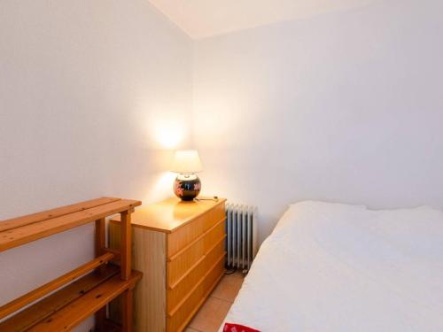 une chambre avec un lit et une lampe sur une commode dans l'établissement Appartement T2 à Narbonne-Plage - 30m de la plage, balcon, 4 couchages, parking gratuit - FR-1-409A-27, à Narbonne