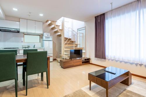 a kitchen and living room with a table and a staircase at Granado Roppongi in Tokyo