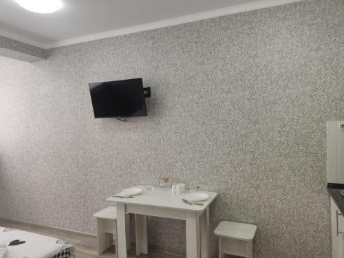 uma mesa branca com uma televisão na parede em Студия №2-65 LifeHouseAlmaty в ЖК Теремки-2 em Almaty