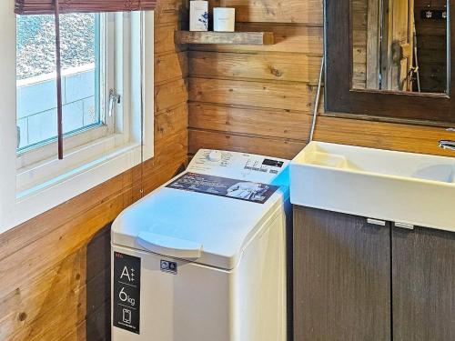 uma pequena cozinha com um lavatório e uma máquina de lavar roupa em Holiday home lyngdal IX em Lyngdal