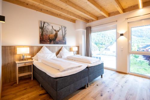 a bedroom with two beds and a large window at Landhotel Ewerts in Insul