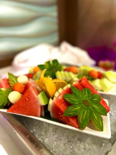 a plate of fruits and vegetables on a table at Langkawi Seaview Hotel in Kuah
